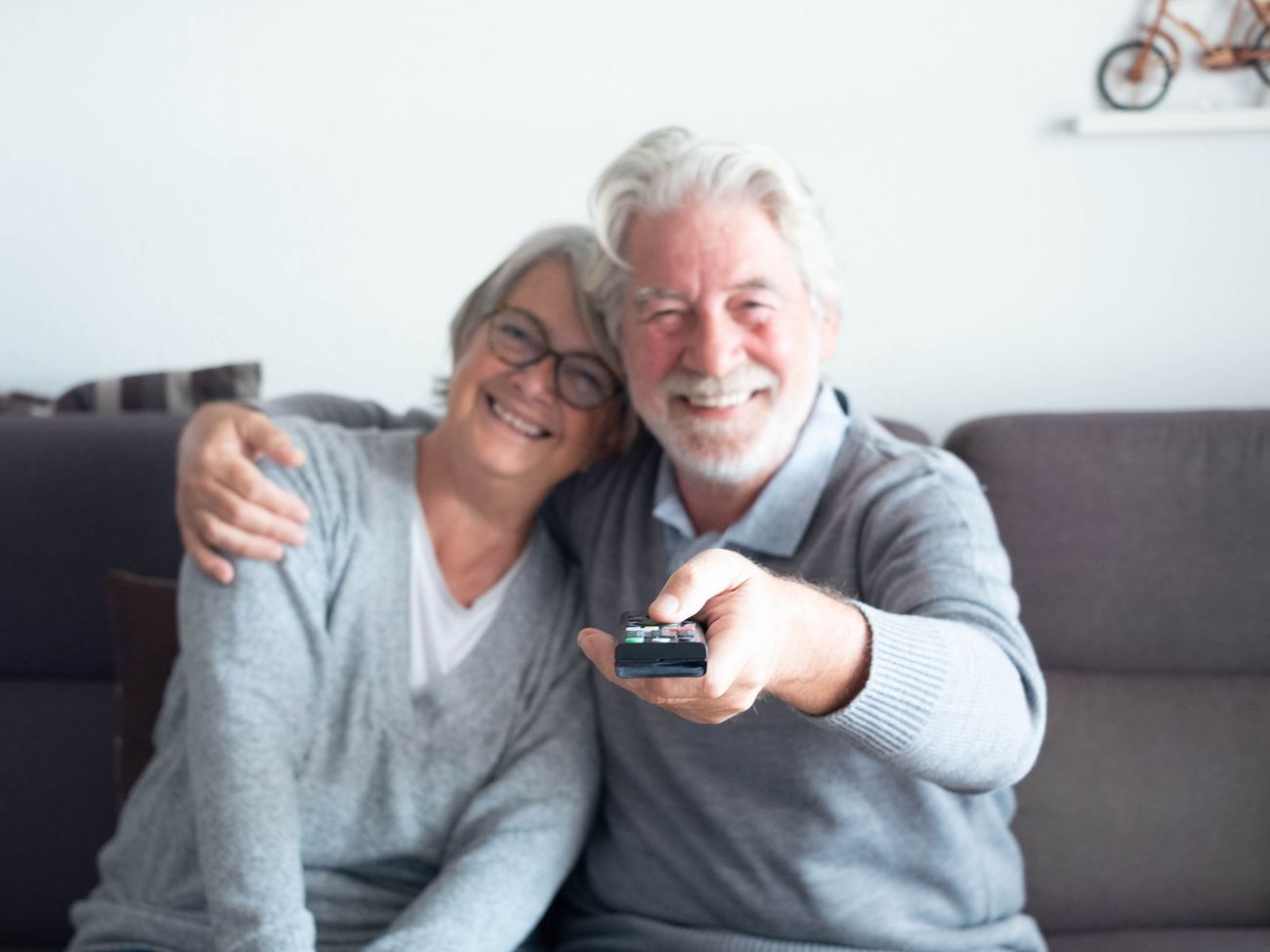 Senior couple at home with the remote