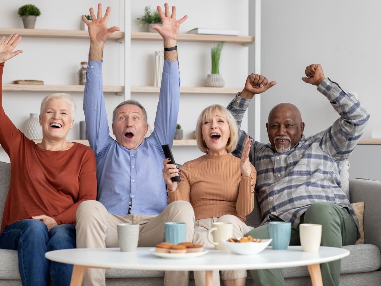 Residents cheering the game together in a senior living lounge