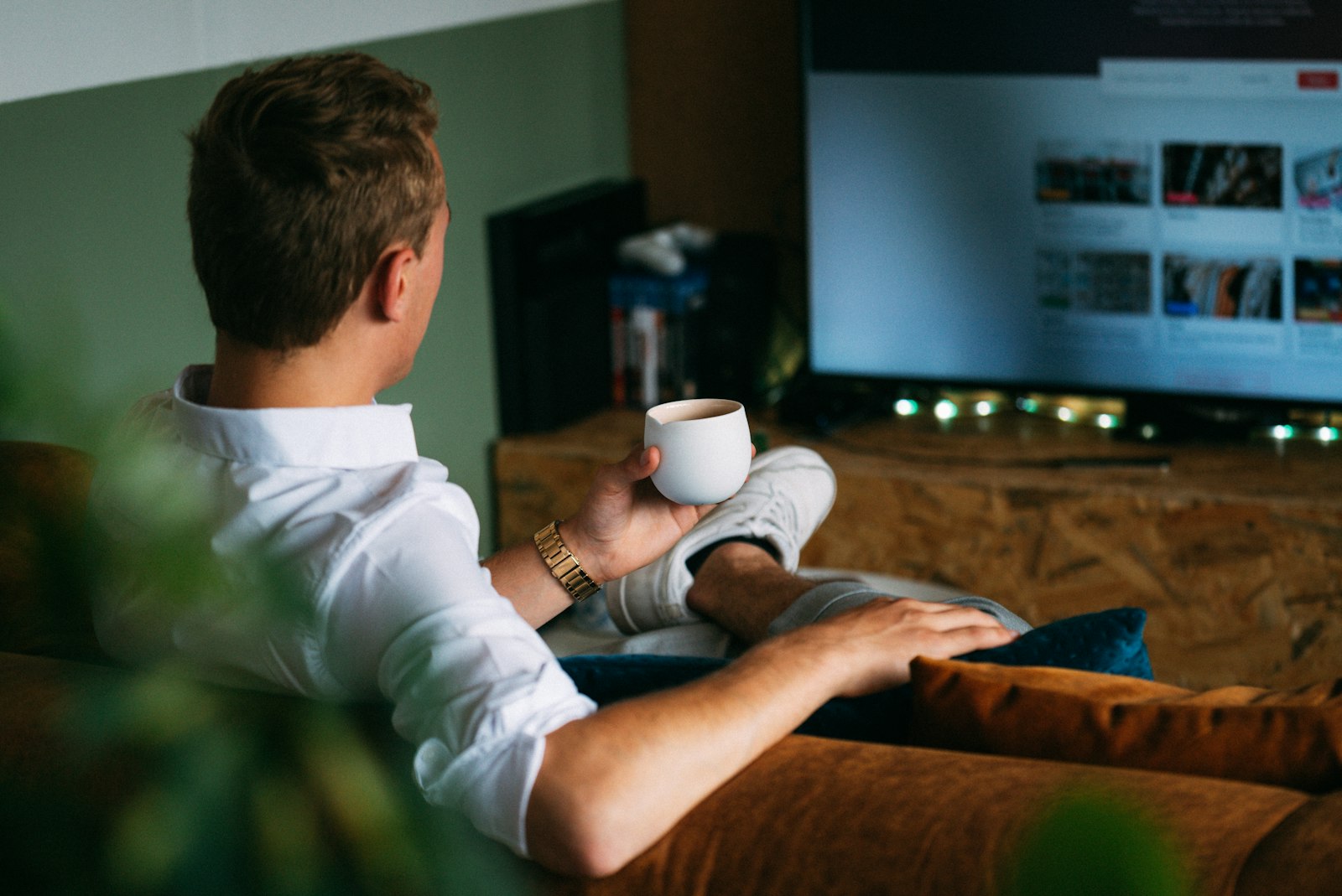 A man relaxing with coffee in front of the TV